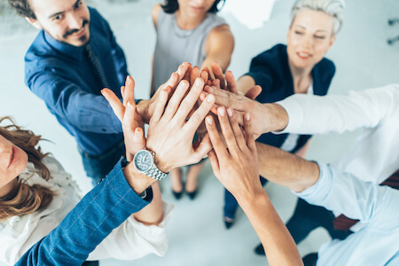 Groupe de personnes joignant les mains en signe de solidarité